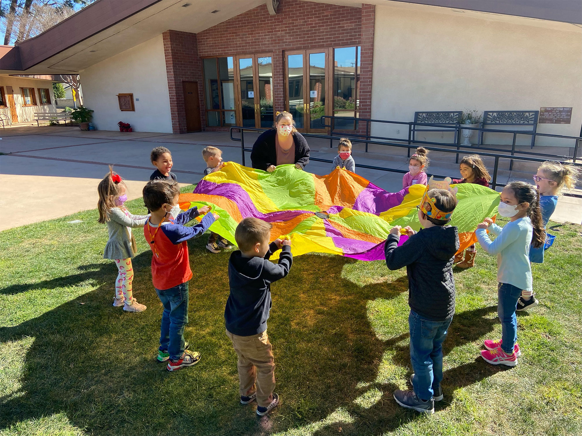 Children Gathered Around Colorful Parachute