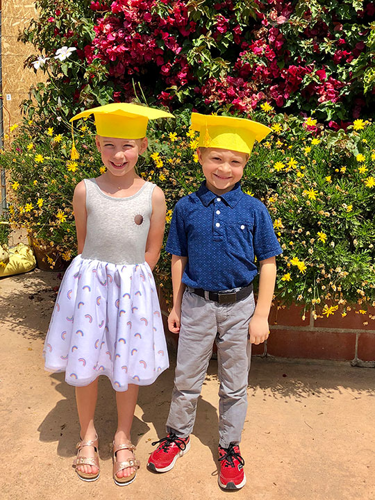 Kindergarten boy and girls with yellow graduation caps on the day of their kindergarten graduation