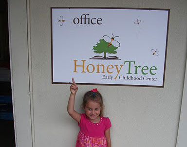Small Child Pointing at the Honey Tree Sign