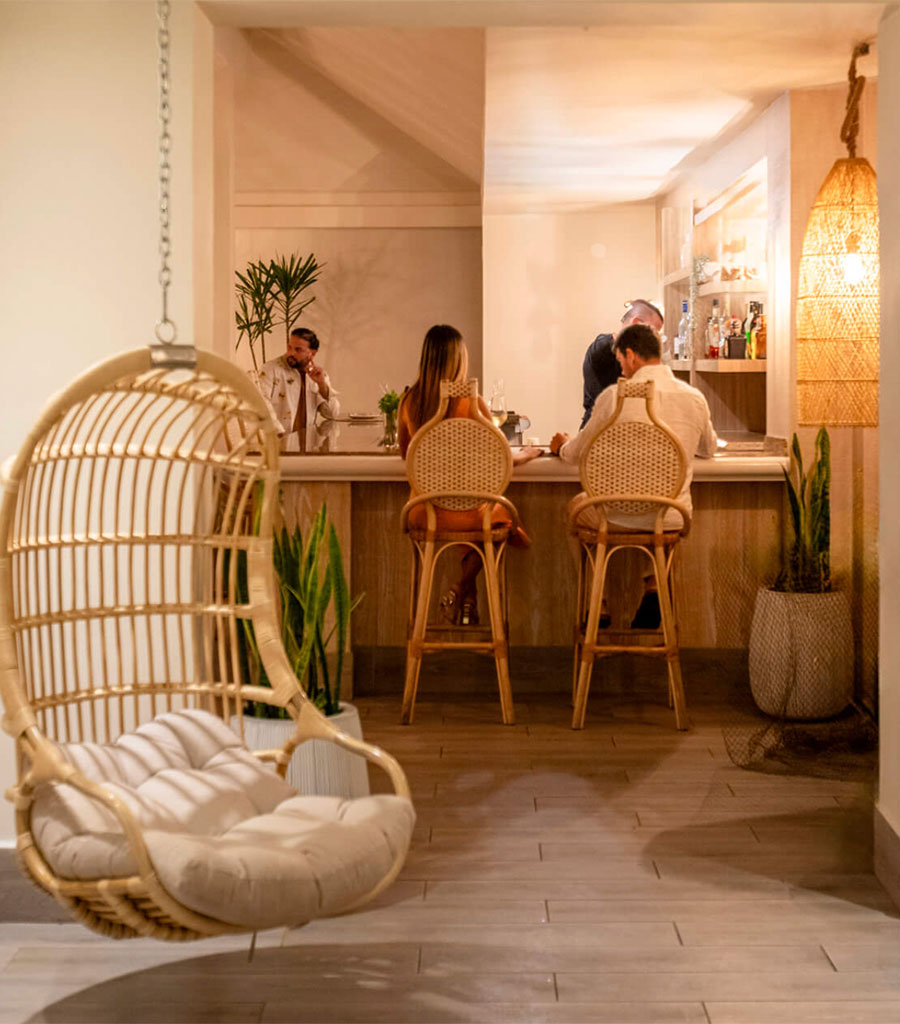 Hanging wicker chair and wicker bar stools are featured in the Wyndham Hotel Las Palmas Del Mar lounge.