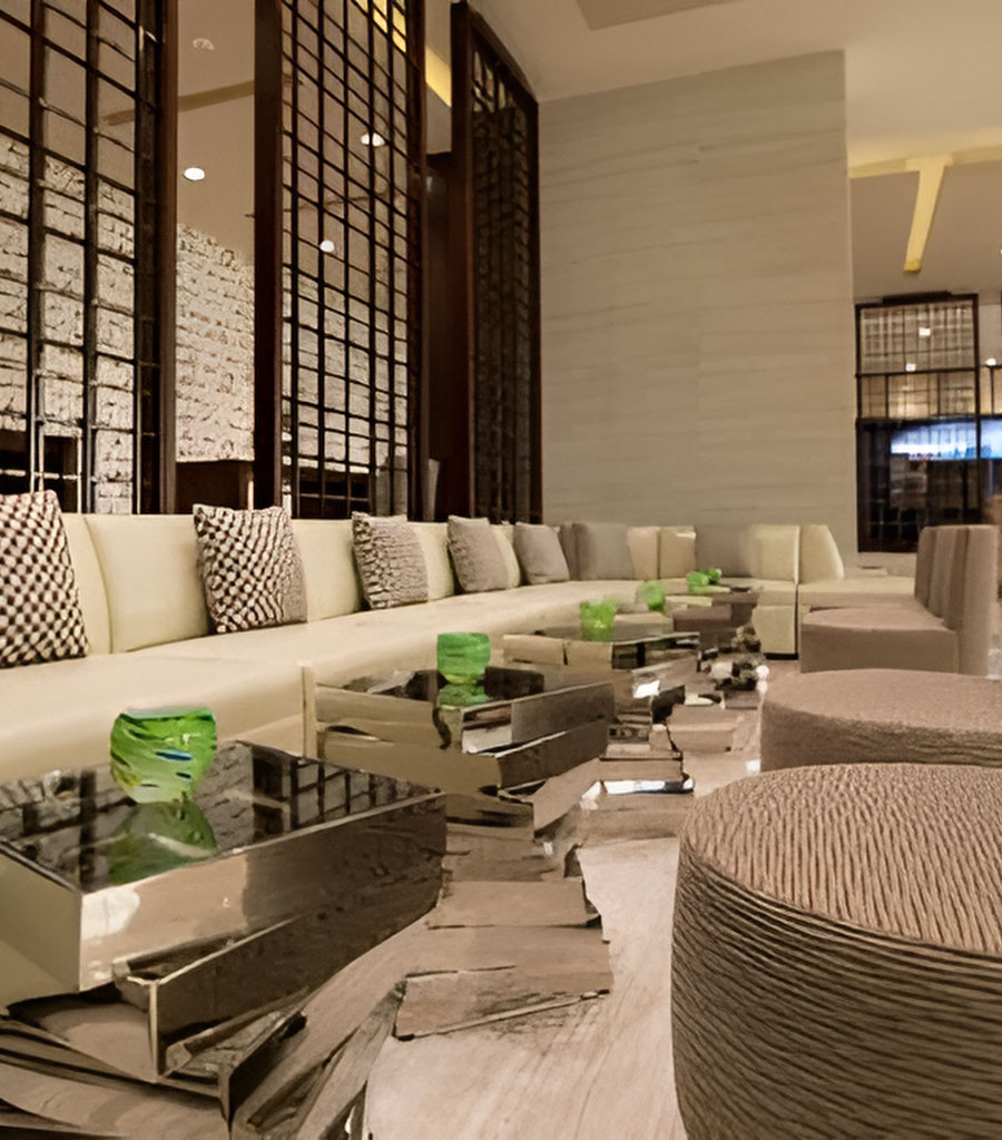 Hilton Panama Lobby featuring long bench seating on one side and soft patterned chairs on the other with small cocktail tables in between.