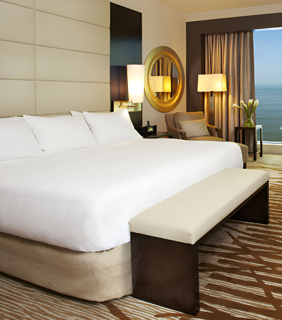 Hilton Panama Lobby featuring white bed linens and tan and brown carpeting.