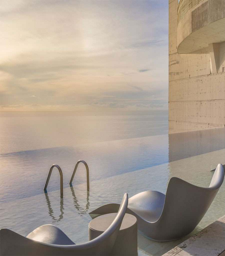JW Marriott Panama Infinity Pool Seating featuring sculpted chairs permanently placed in the infinity pool overlooking the pool and the ocean beyond.