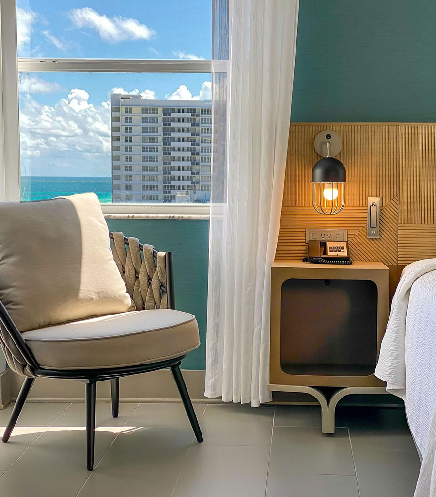 Marseilles Hotel Guest Room featuring white linens and earth tone colors elsewhere.