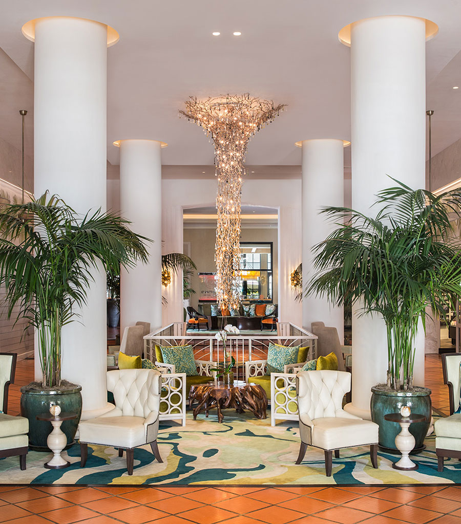 The Palms Hotel Miami Lobby featuring large potted palm trees flanked by large arm chairs