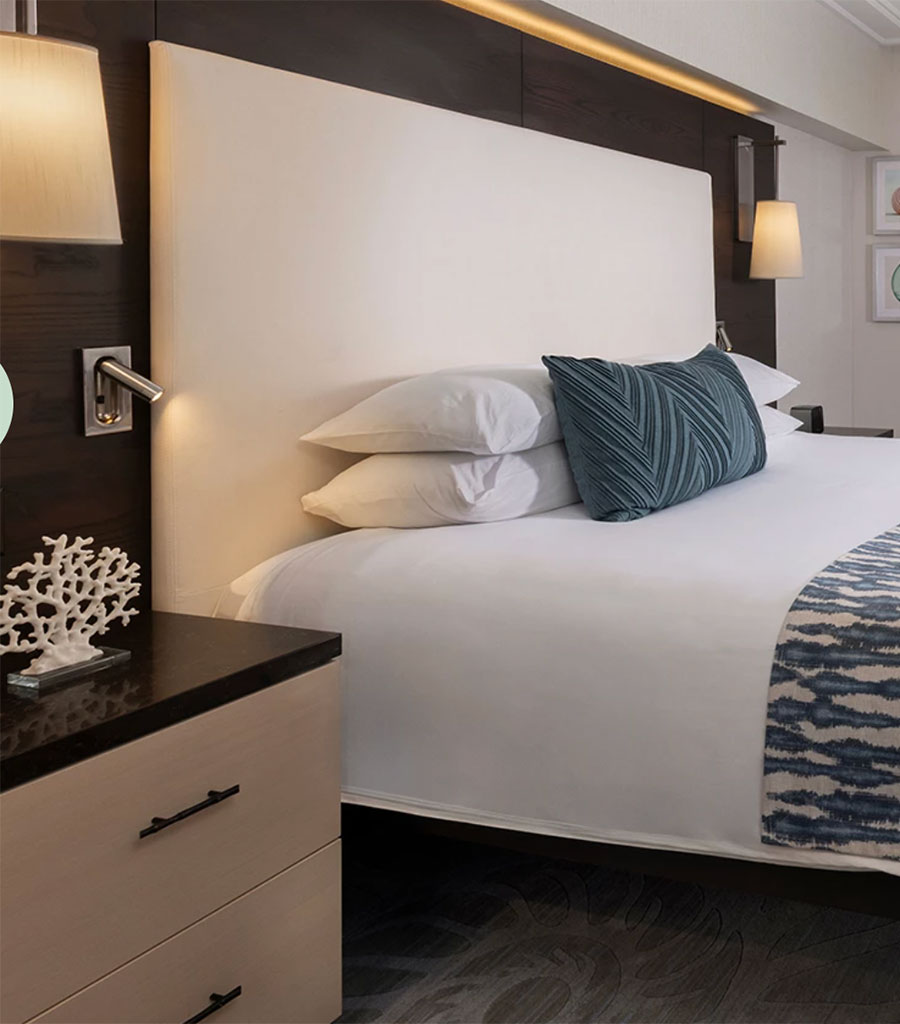The Palms Hotel Miami guest room with white linens and accents of green to highlight the palm motif.