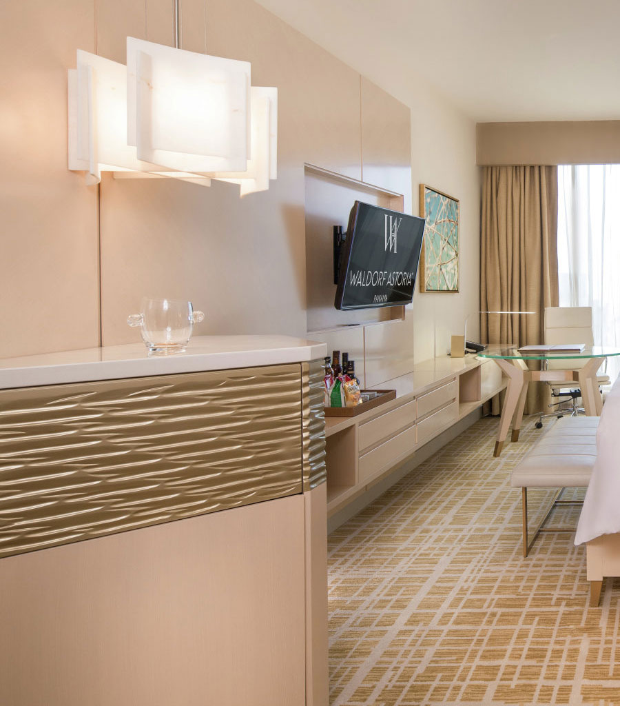 Waldorf Astoria Panama Guest Room featuring built in bar, built-in cabinetry and a large screen TV
